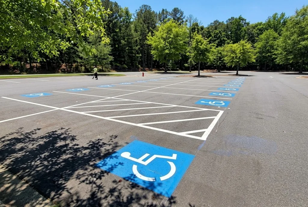 Newly striped asphalt parking lot with blue ADA handicap symbols and white parking space lines